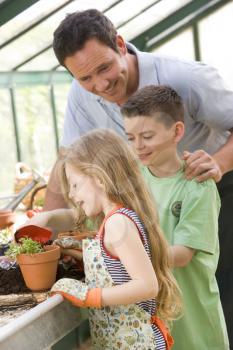 Royalty Free Photo of a Man in a Greenhouse With Children