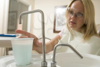 Royalty Free Photo of a Dental Patient Getting Water