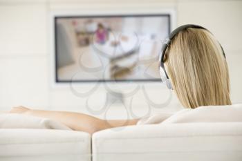 Royalty Free Photo of a Woman Watching Television With Headphones On