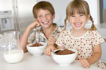 Royalty Free Photo of Two Children Eating Cereal