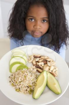 Royalty Free Photo of a Girl Eating Rice Fruit and Nuts