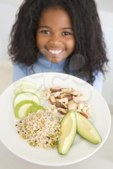 Royalty Free Photo of a Child With a Plate of Rice, Fruit and Nuts