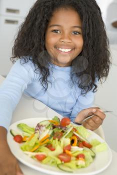 Royalty Free Photo of a Little Girl Eating Salad