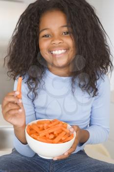 Royalty Free Photo of a Girl Eating Carrot Sticks
