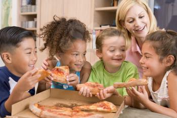 Royalty Free Photo of Four Children Eating Pizza