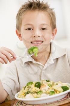 Royalty Free Photo of a Boy Eating Broccoli and Pasta