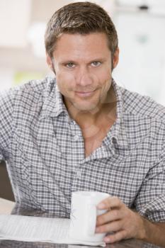 Royalty Free Photo of a Man Reading a Newspaper and Having a Coffee