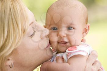 Royalty Free Photo of a Mother Kissing a Baby