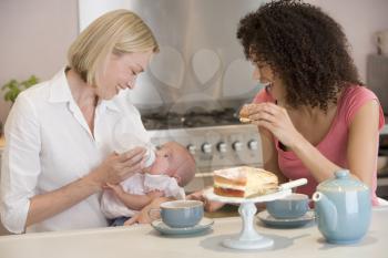 Royalty Free Photo of Two Women in a Kitchen With a Baby