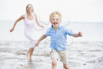 Royalty Free Photo of a Mother and Son Running at the Beach
