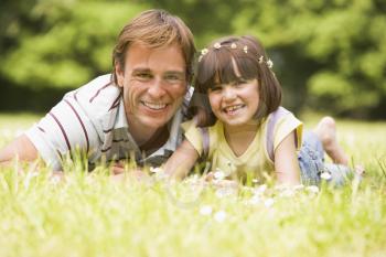 Royalty Free Photo of a Father and Daughter Lying in the Grass