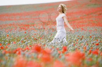 Royalty Free Photo of a Woman Walking in a Poppy Field