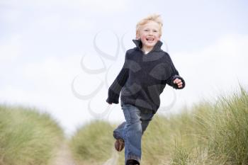 Royalty Free Photo of a Boy Running on aSand Dunes