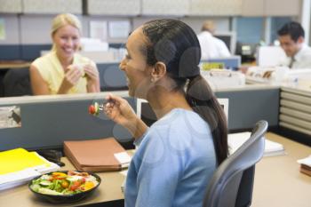 Royalty Free Photo of a Woman Having Lunch in an Office Cubicle