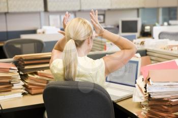 Royalty Free Photo of a Woman in an Office Cubicle With a Stack of Files