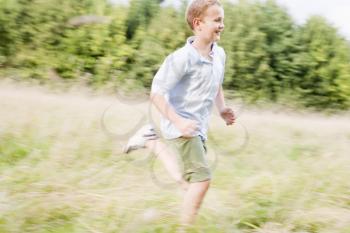 Royalty Free Photo of a Boy Running in a Field
