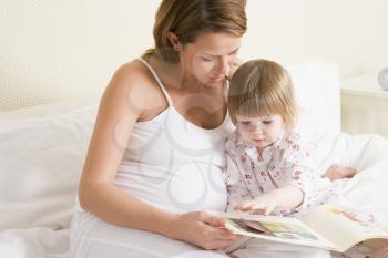 Royalty Free Photo of a Pregnant Woman Reading to Her Daughter