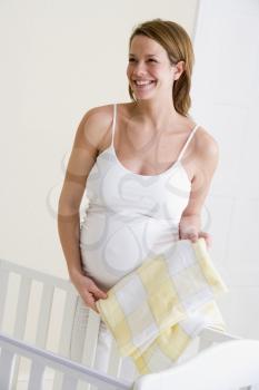 Royalty Free Photo of a Pregnant Woman Setting Up a Baby Crib