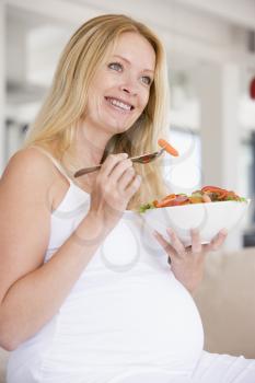 Royalty Free Photo of a Pregnant Woman Eating a Salad