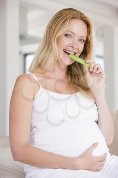Royalty Free Photo of a Pregnant Woman Eating Celery
