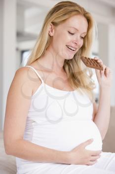 Royalty Free Photo of a Pregnant Woman Eating a Chocolate Bar