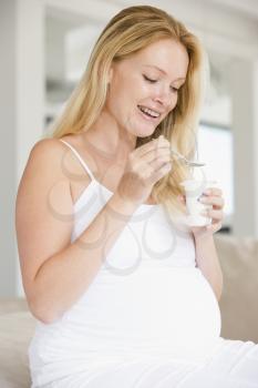 Royalty Free Photo of a Pregnant Woman Eating Yogourt