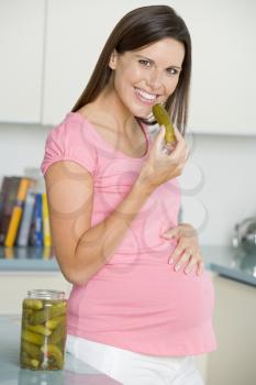 Royalty Free Photo of a Pregnant Woman Eating Pickles