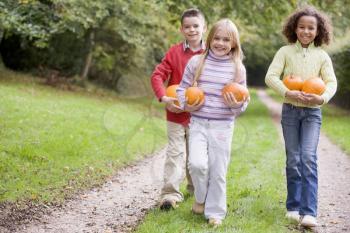 Royalty Free Photo of Children Walking on a Path With Pumpkins
