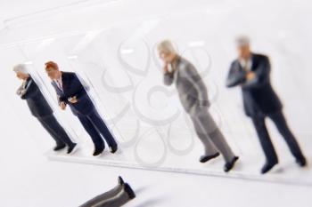 Royalty Free Photo of a Row of Businessman Figurines With One Down