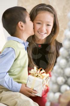 Royalty Free Photo of a Brother Kissing His Sister and Giving Her a Gift