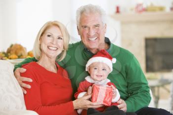 Royalty Free Photo of Grandparents With a Baby in a Santa Costume