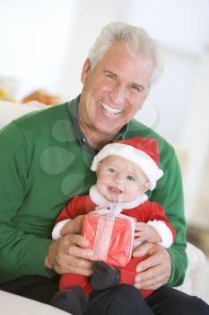 Royalty Free Photo of a Grandfather With a Baby in a Santa Costume