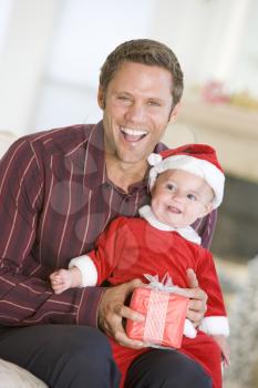 Royalty Free Photo of a Father With a Baby in a Santa Suit