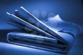 Royalty Free Photo of a Folded Newspaper on Blue