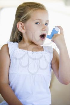 Royalty Free Photo of a Girl Using an Inhaler