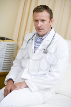 Royalty Free Photo of a Doctor Sitting on a Hospital Bed