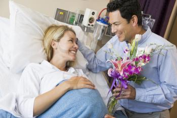 Royalty Free Photo of a Man Giving His Pregnant Wife Flowers