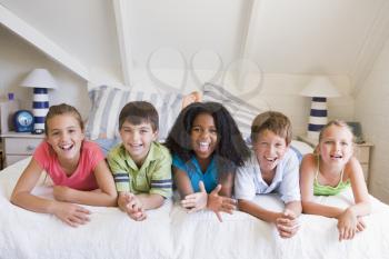 Royalty Free Photo of Five Friends on a Bed