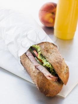 Royalty Free Photo of a Ham And Salad Granary Baguette With Mango And Banana Smoothie And A Nectarine