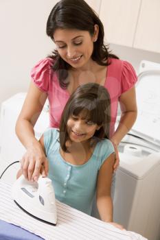 Royalty Free Photo of a Mother and Daughter Ironing