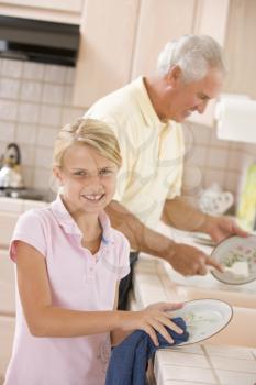 Royalty Free Photo of a Girl Helping Her Grandfather With Dishes