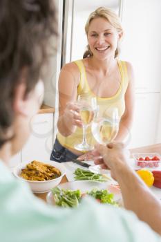 Royalty Free Photo of a Woman and Her Husband Drinking Wine While Preparing a Meal
