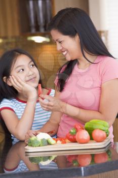 Royalty Free Photo of a Mother and Daughter Chopping Vegetables