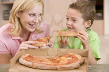 Royalty Free Photo of a Mother and Son Eating Pizza