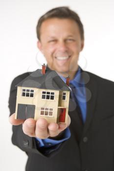 Royalty Free Photo of a Man Holding a Small House