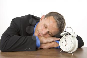 Royalty Free Photo of a Sleeping Businessman With an Alarm Clock