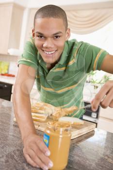 Royalty Free Photo of a Teen Making a Peanut Butter Sandwich