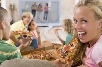 Royalty Free Photo of Teens Watching TV and Eating Pizza