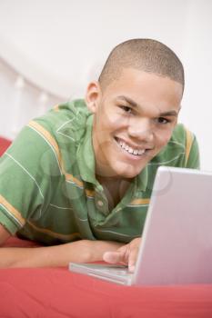 Royalty Free Photo of a Boy in Bed With a Laptop