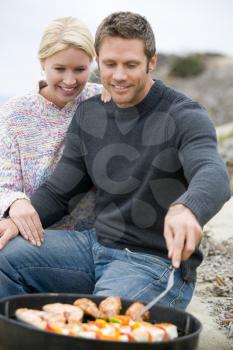 Royalty Free Photo of a Couple Barbecuing at the Beach